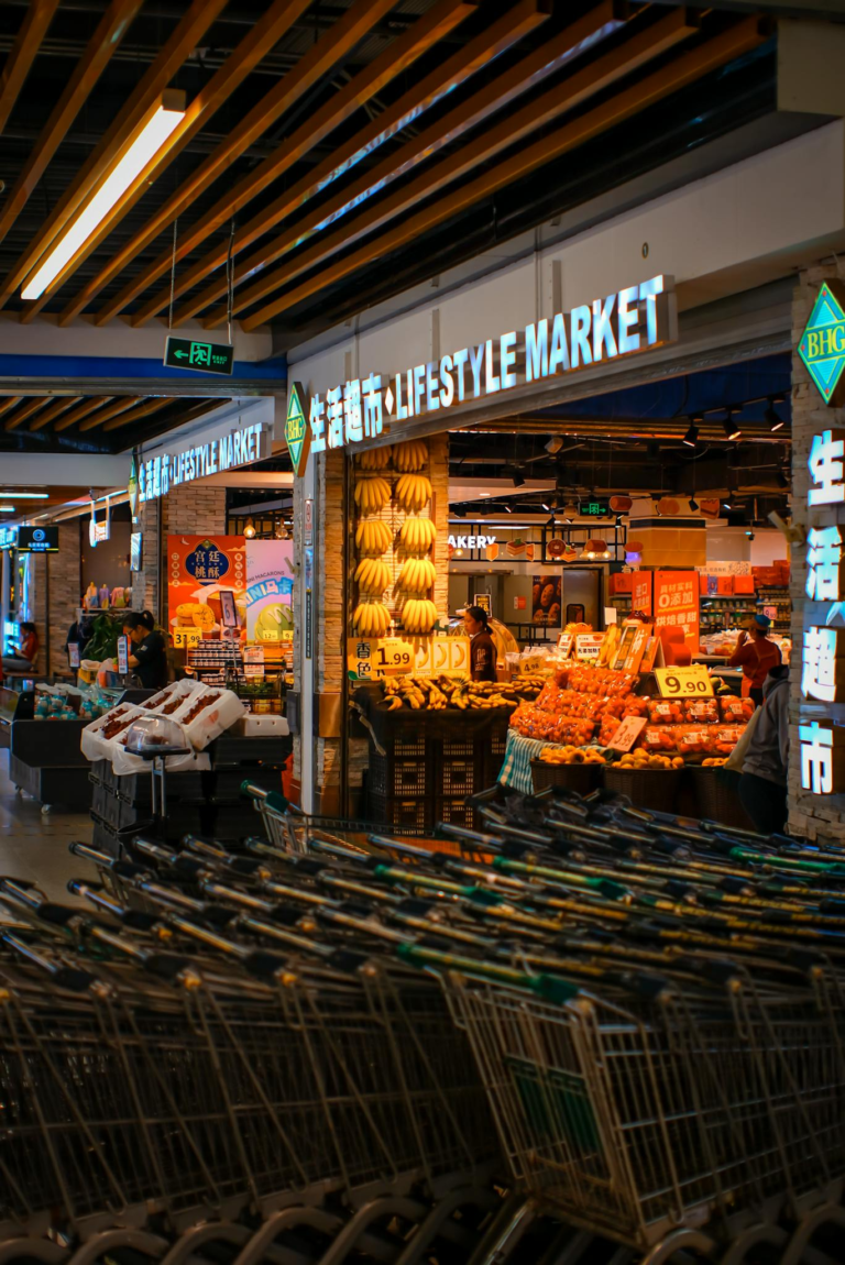 Vibrant indoor lifestyle market featuring carts, fresh fruits, and bakery items under warm lighting.